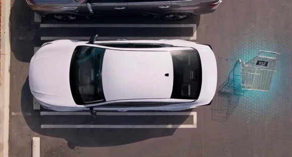 Top view of a white 2027 Nissan Altima in a parking lot with rear sensors detecting a shopping cart behind it at Gerweck Nissan in Monroe MI